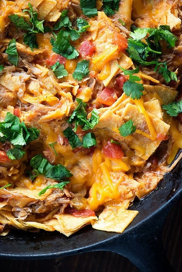 A close up of pulled pork and melted cheese in a cast-iron skillet.
