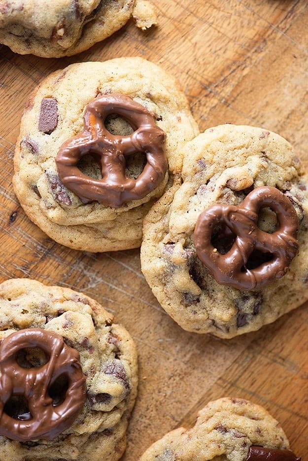 A chocolate chip cookie with a chocolate covered pretzel on top.