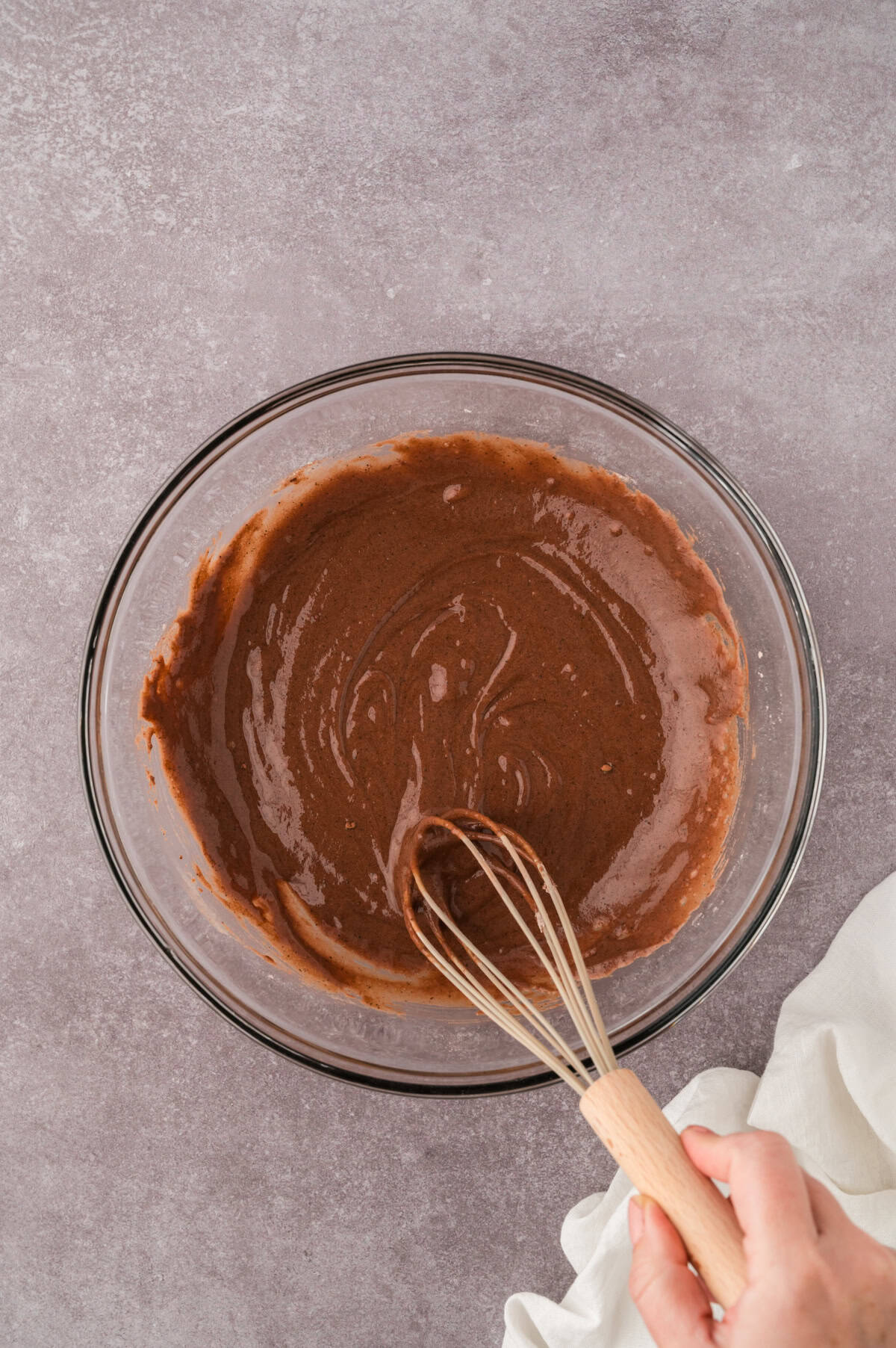Ingredients for chocolate cobbler filling mixed in a glass bowl.