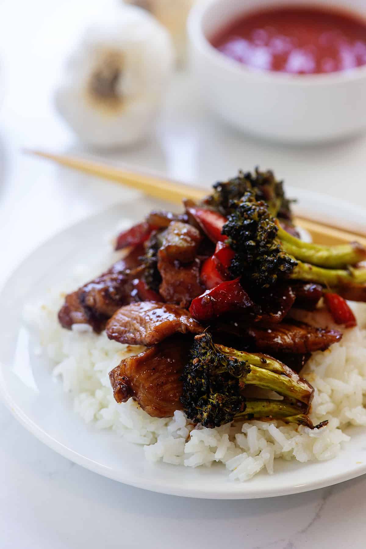 pork stir fry on white plate with rice.