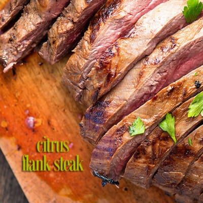 A filleted flank steak on a wooden cutting board.