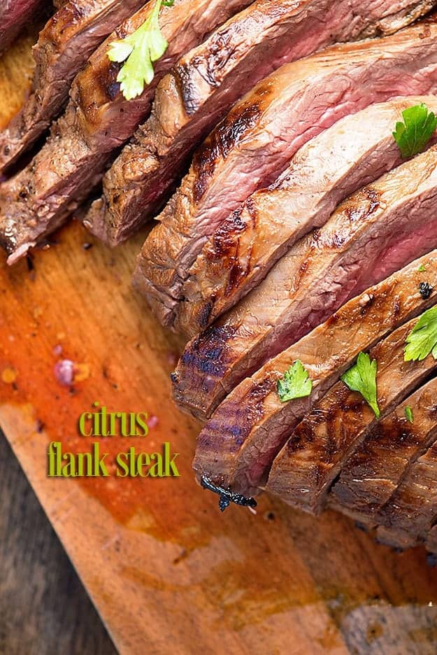 A filleted flank steak on a wooden cutting board.