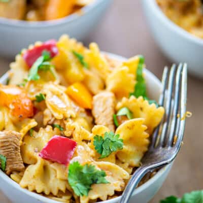 chicken fajita pasta in white bowl with vintage fork.