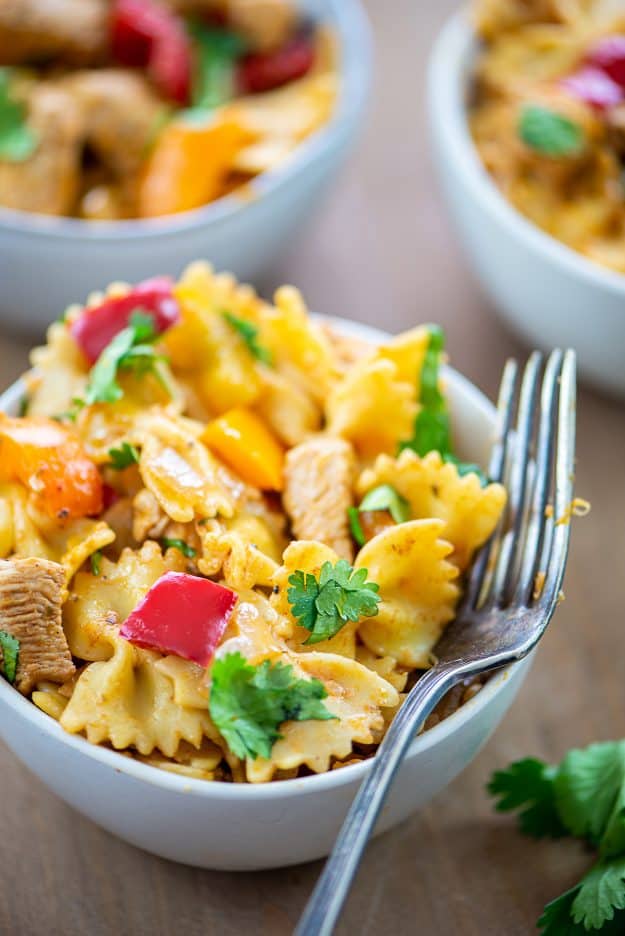 chicken fajita pasta in white bowl with vintage fork.