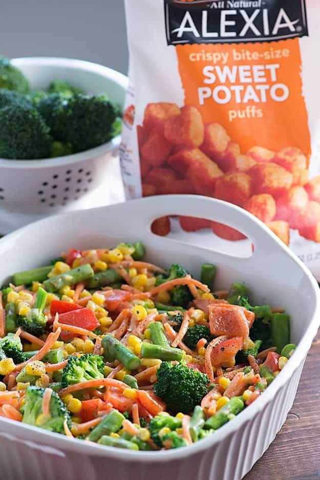 A bunch of vegetables in a white handled baking dish.