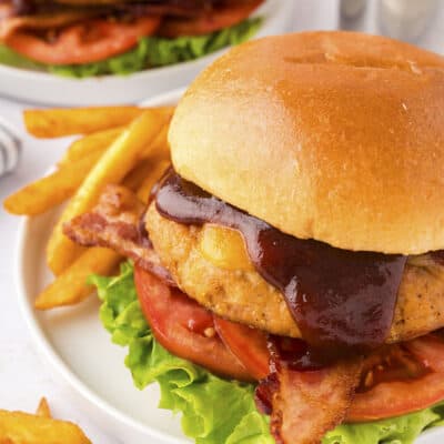 Chicken burger with barbecue sauce and bacon on bun.