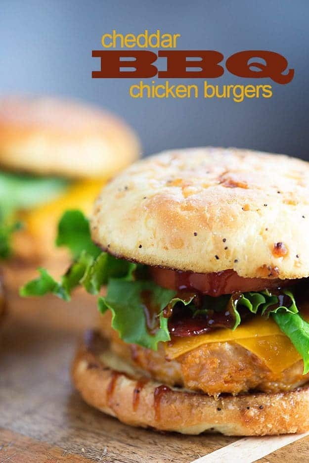 A close up of a chicken cheeseburger in front of another chicken cheeseburger in the background.