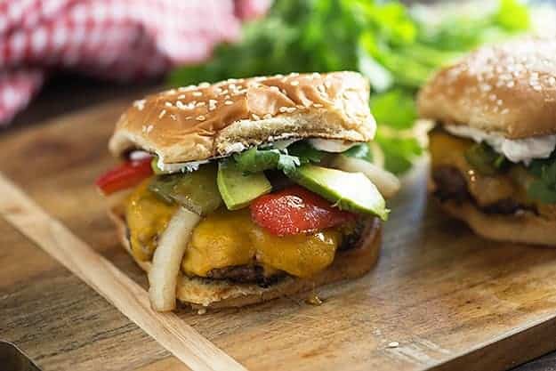 These fajita burgers are topped with grilled veggies, avocado, cheese, and a dollop of sour cream! Perfect for summer grilling.
