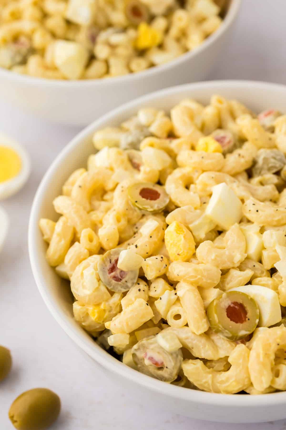 classic macaroni salad in white bowls.