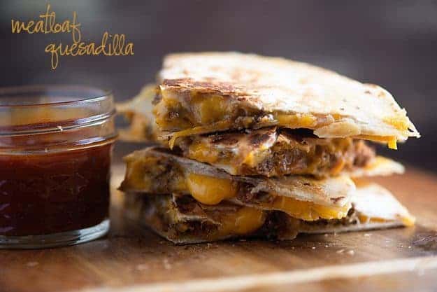 Stacked up quesadillas on a wooden cutting board.