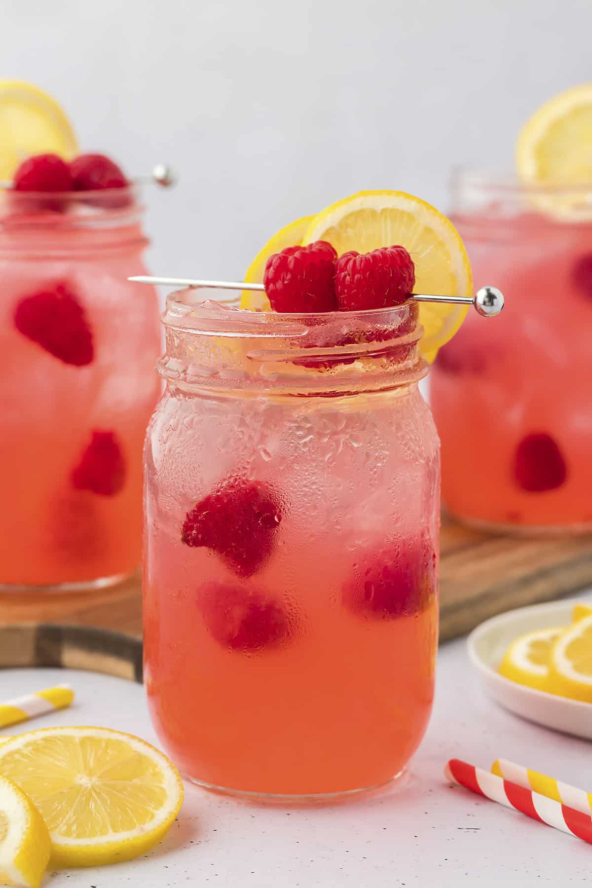 Cocktail made with vodka and raspberries in glass mason jar.