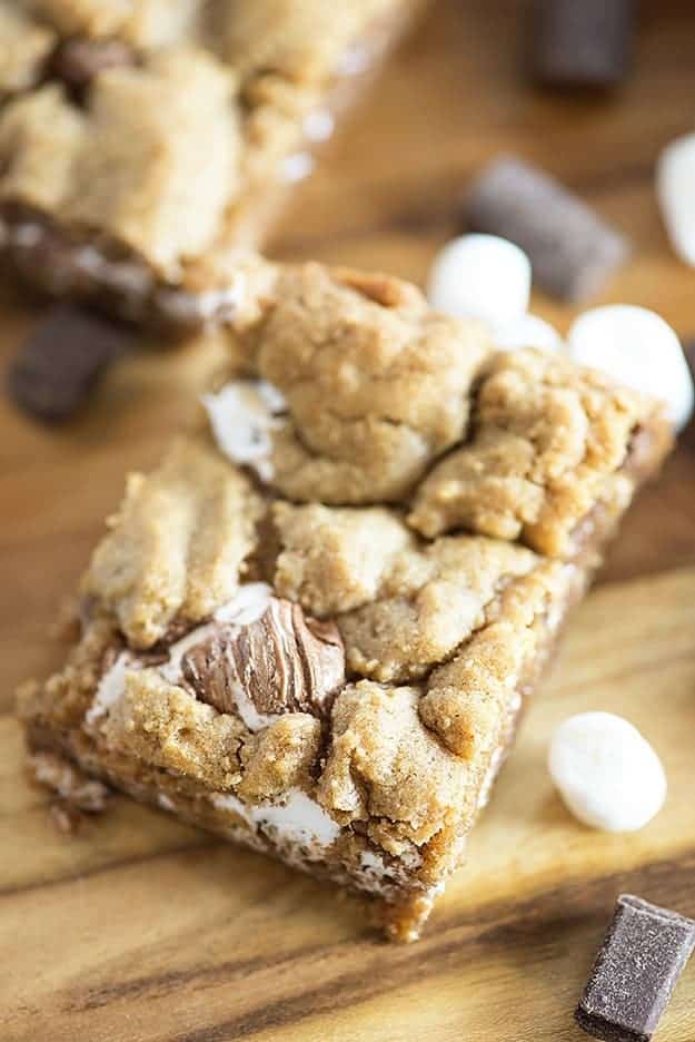 A close up of a smores bar on a wooden cutting board.