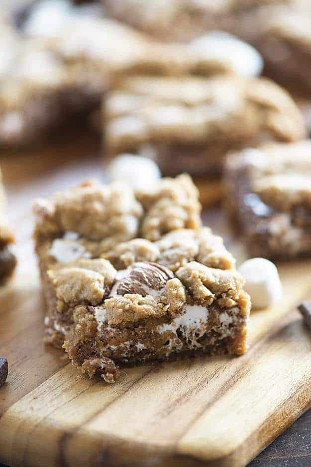 A close up of a smores bar on a wooden cutting board.