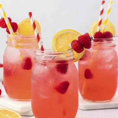Raspberry vodka collins in glass jars.