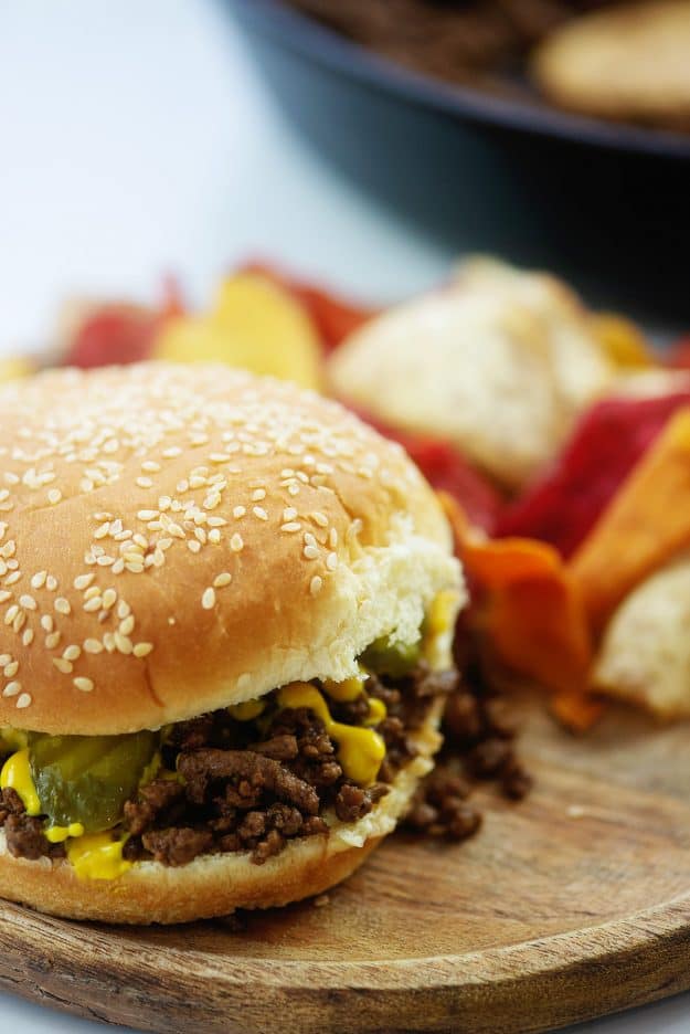 maid rite burger on wooden board with chips.