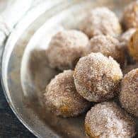Baked pumpkin donut holes! These are dense like a pumpkin pie, but coated in butter, cinnamon, and sugar so they taste like a fried donut!