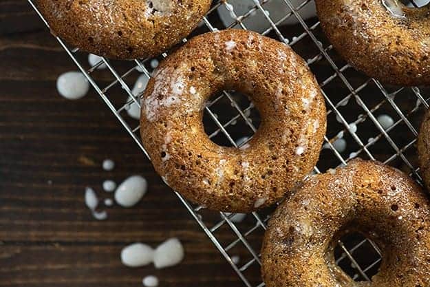 A donut on a wire cooling rack topped with glaze.