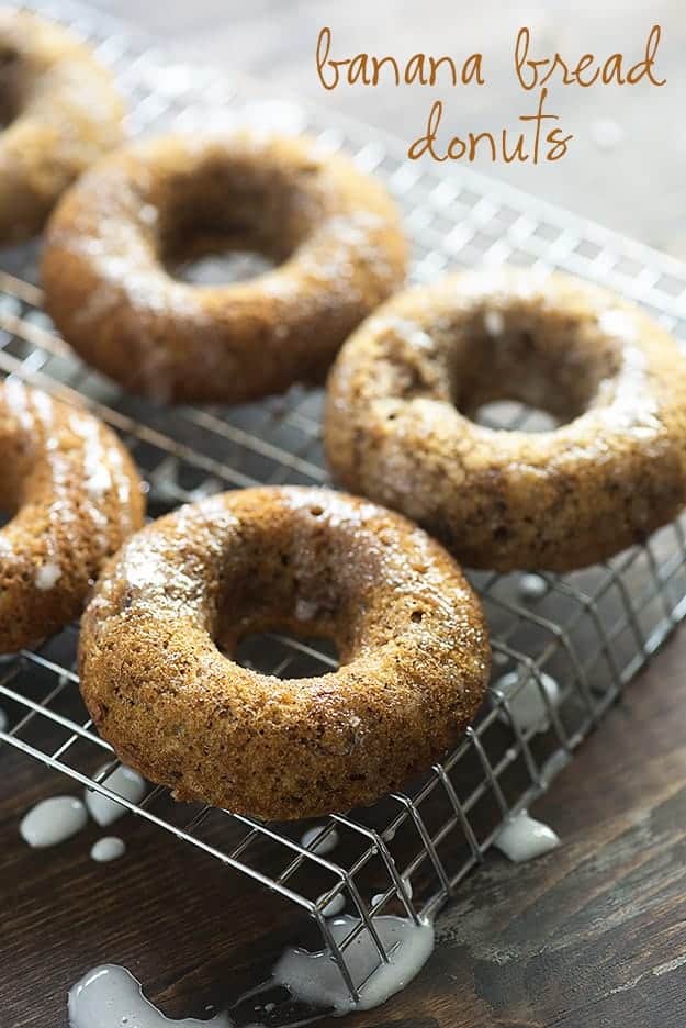 Four banana donuts on a wire cooling rack.