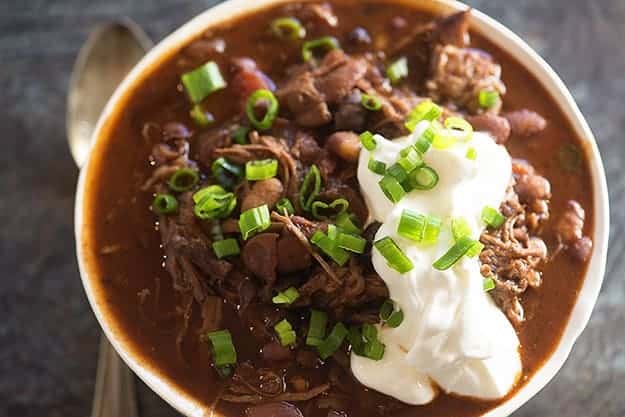 Aan overhead view of chili with chives and sour cream on top.