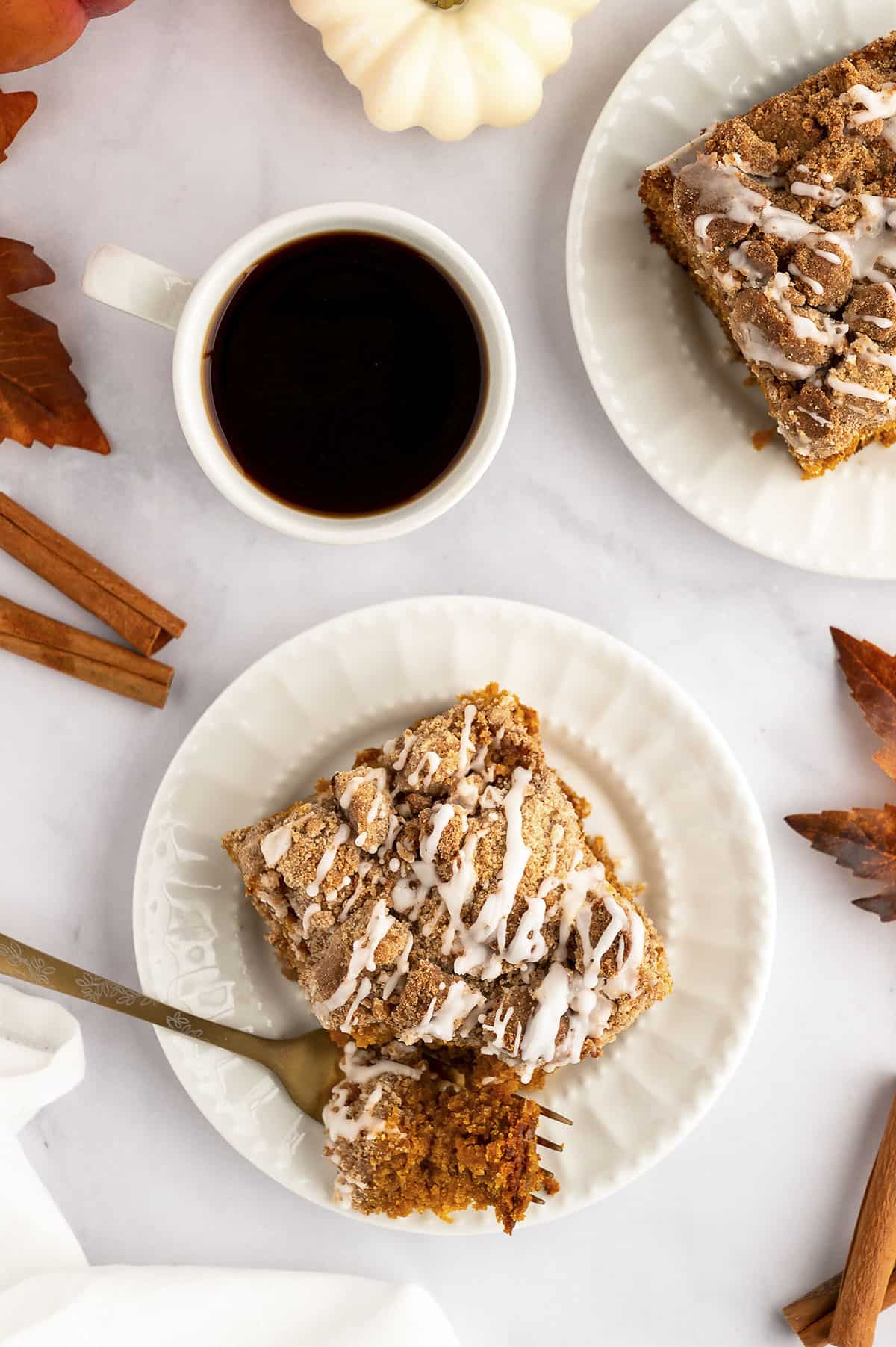 Pumpkin cake on white plate with cup of coffee.