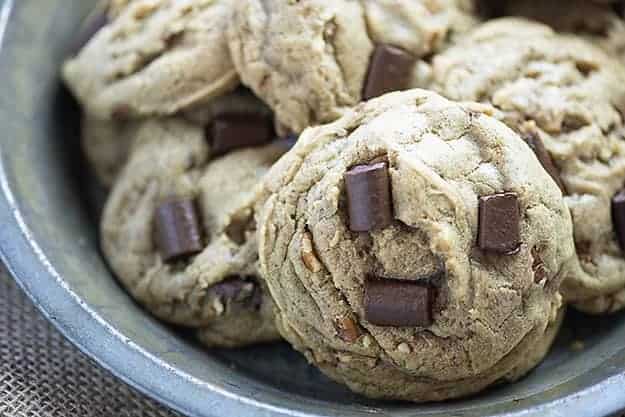 A close up of cookies with large toffee chunks in them.