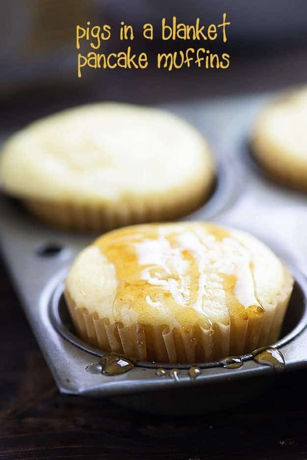 A muffin pan of with syrup drizzled over pancake muffins.