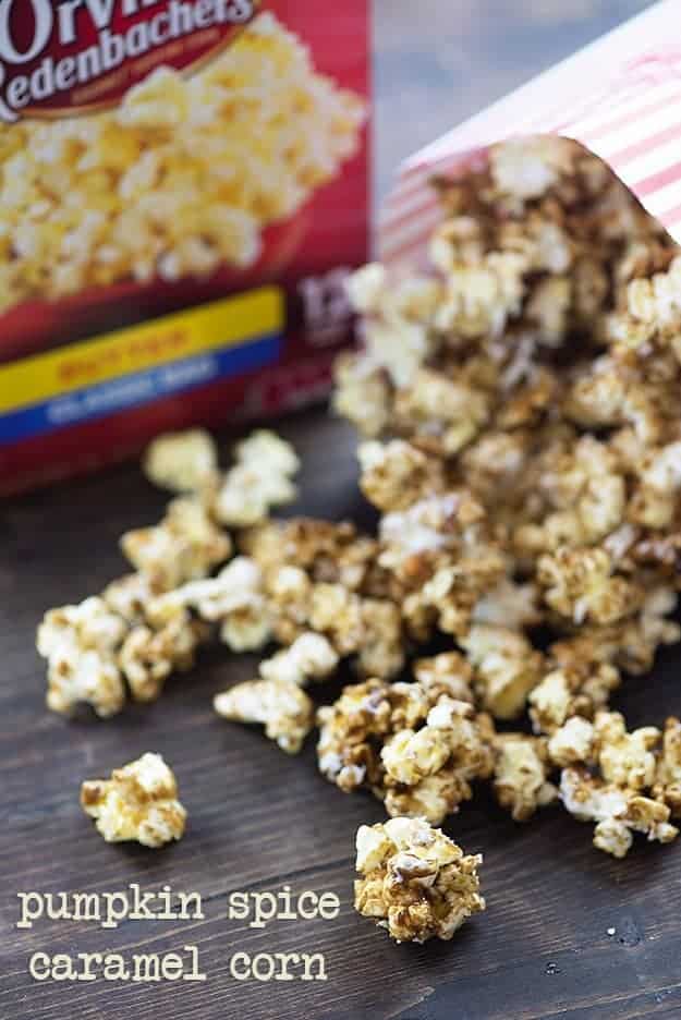 A bag of caramel corn spilling onto a wooden table.