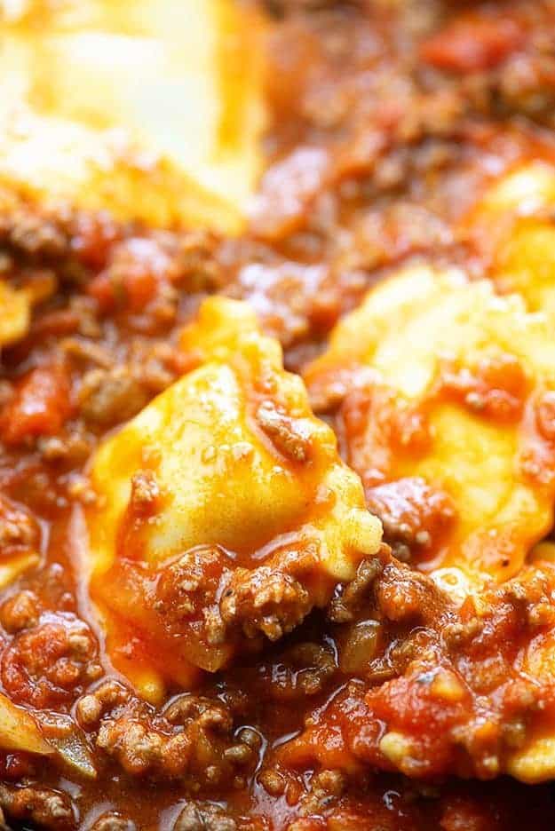 A close up of ravioli with meat sauce.
