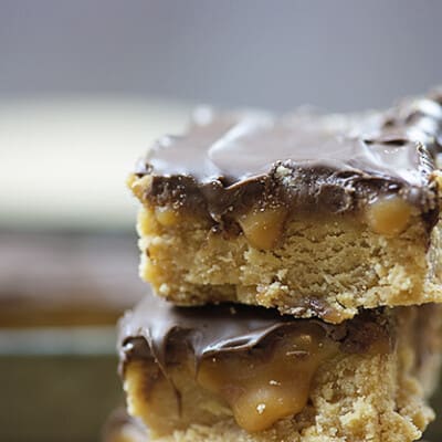 A couple stacked up chocolate peanut butter bars.