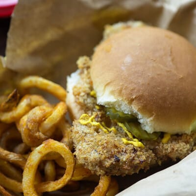 pork tenderloin sandwich in basket with fries.