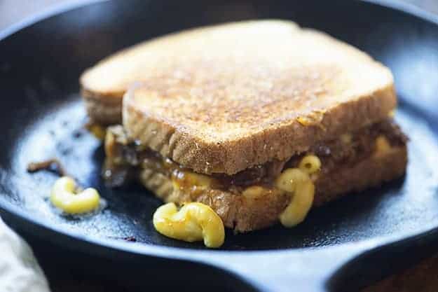 A barbecue mac and cheese sandwich cooking in a cast-iron skillet.