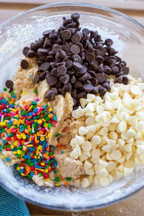 sprinkles and chocolate chips in bowl of cookie dough.