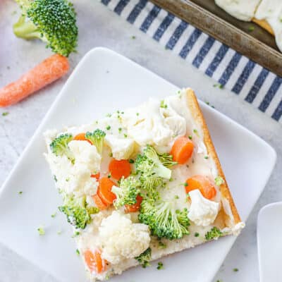 cream cheese veggie pizza on white plate.