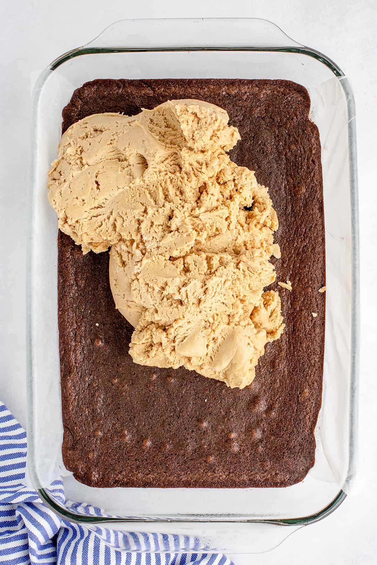 Peanut butter frosting spread over brownies.