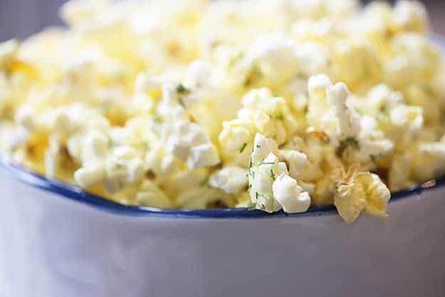 A close up of a white bowl of popcorn.
