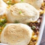 Sloppy joe topped with biscuits in a white baking dish.