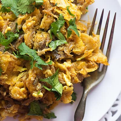 A plate of chilaquiles with a silver fork on it.