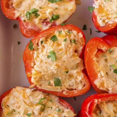 Chicken stuffed peppers in white baking dish.