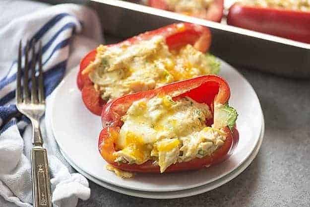 Stuffed red peppers on a white plate.