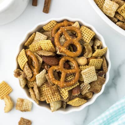 Chex mix in small scalloped dish.