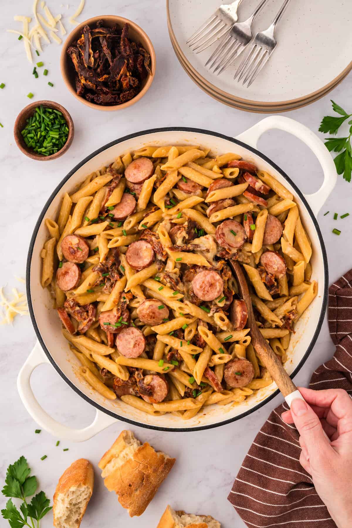 Smoked sausage pasta in white skillet.