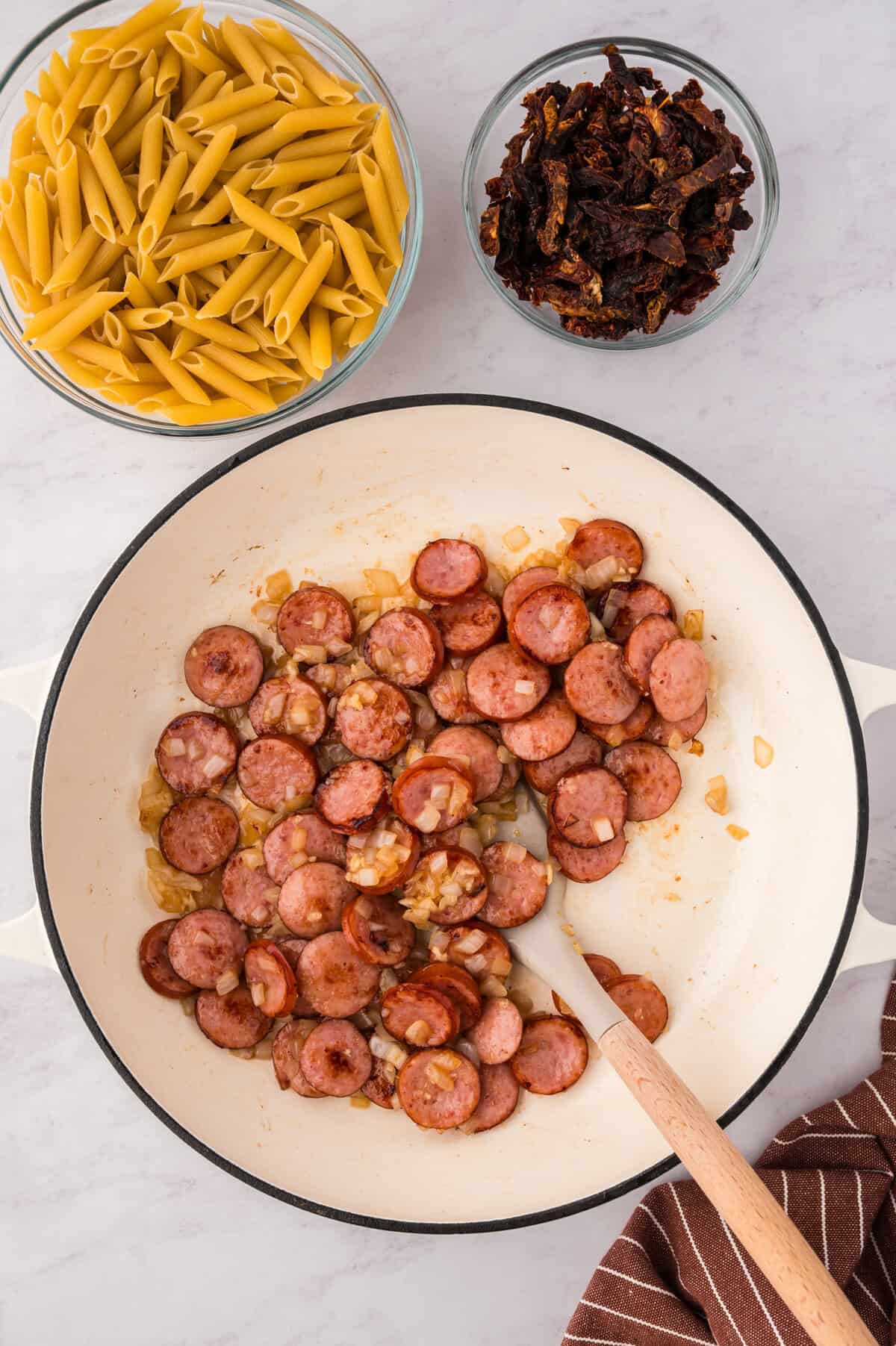 Smoked sausage and onions in a skillet.