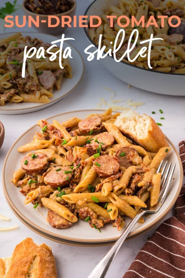 Sun-dried tomato pasta with smoked sausage on plate.