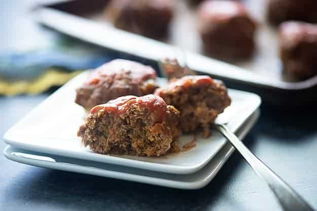 A piece of a meatloaf meatball on a square plate.