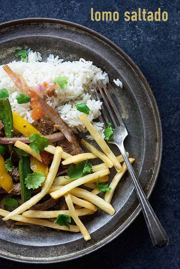 A plate of various vegetables, french fries, and rice.