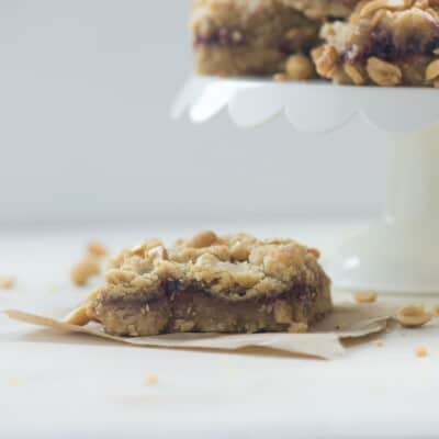 A square peanut butter and jelly cookie on a napkin.