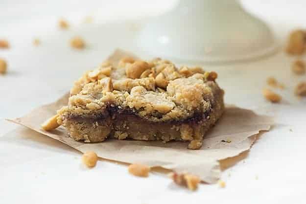 A close up of peanut butter and jelly square on a napkin.