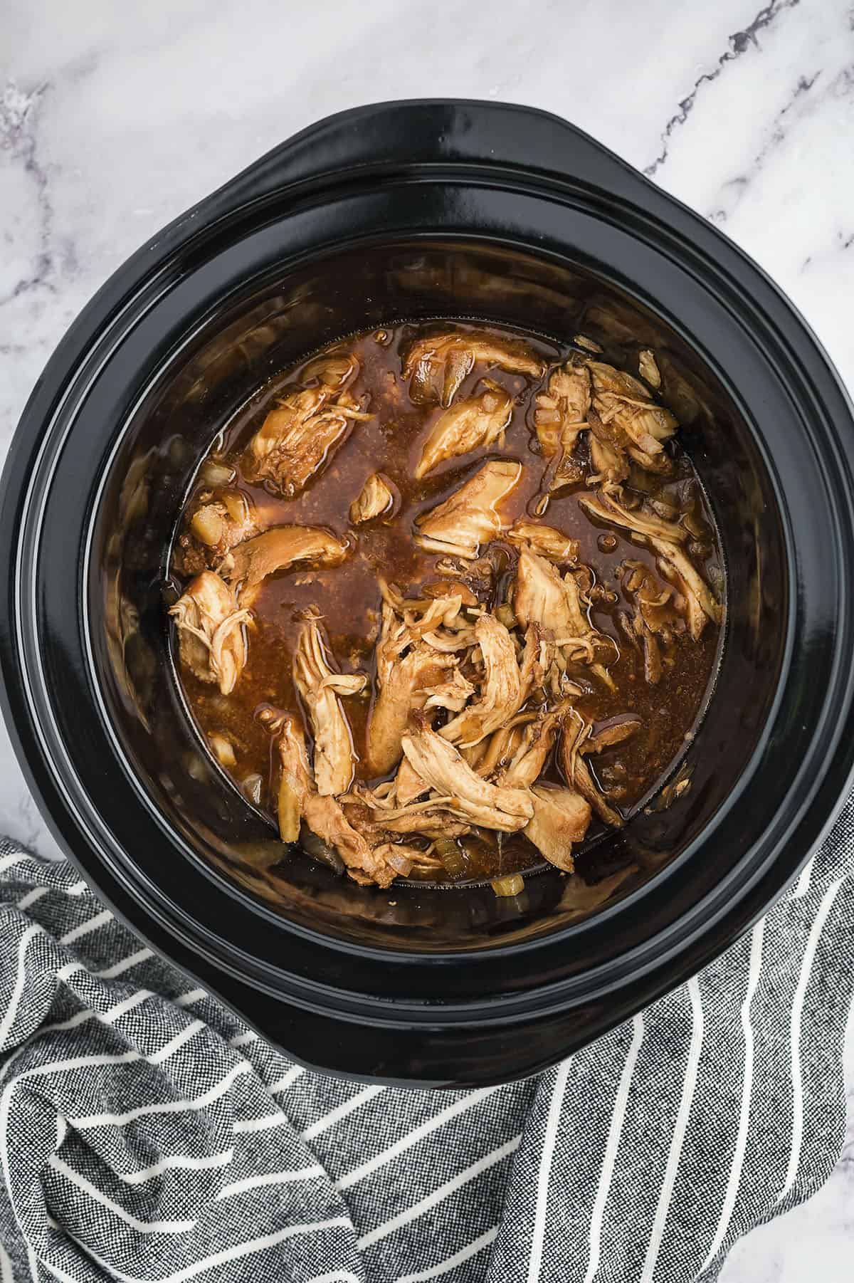 Cooked bourbon chicken in crockpot.