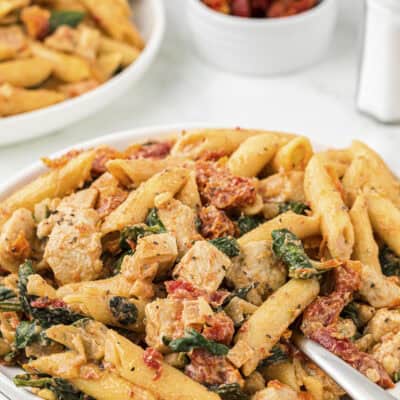 Chicken florentine pasta on small white plate.
