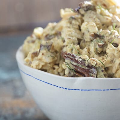 Chicken salad in a white bowl with a blue stripe.